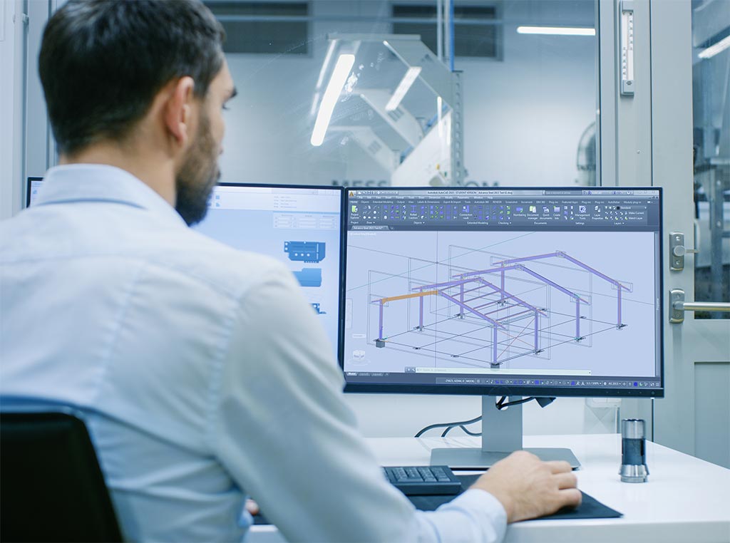 Mężczyzna projektujący halę stalową na komputerze